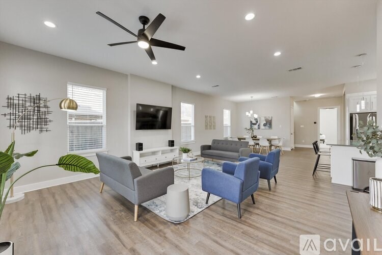 A living room with a grey couch, blue armchair, and a television.