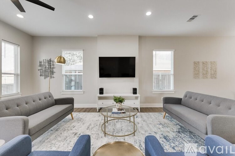 A living room with a grey sofa, a coffee table, and a television.
