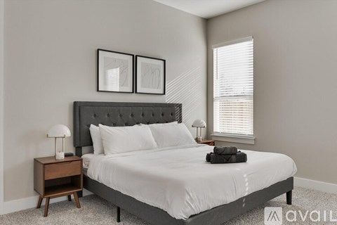 A bedroom with a large bed and two lamps on side tables.