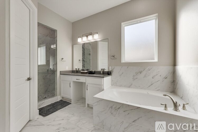 A bathroom with a marble floor and a large white bathtub.