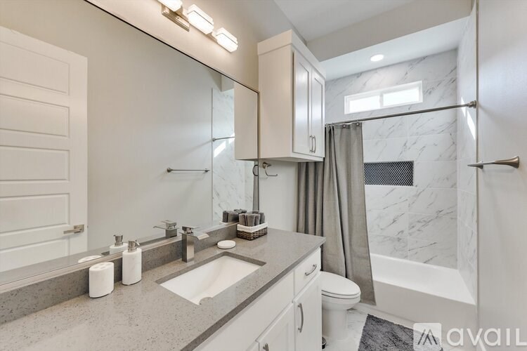 A bathroom with a marble countertop and a walk-in shower.