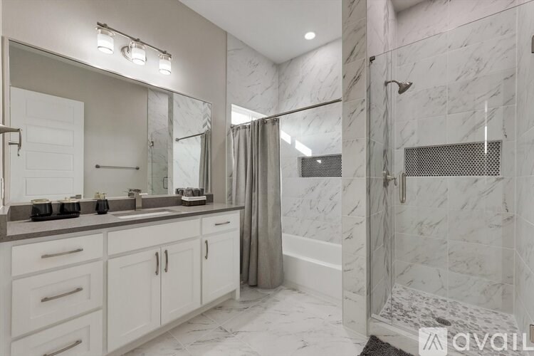 A bathroom with marble tiles and a walk-in shower.