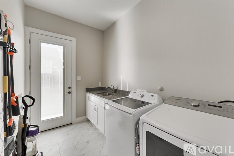 A kitchen with white appliances and a white door.