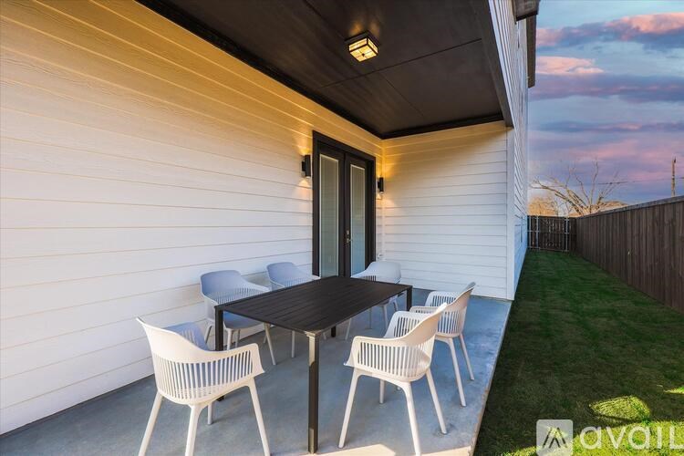 A patio with a table and chairs is set up outside a house.