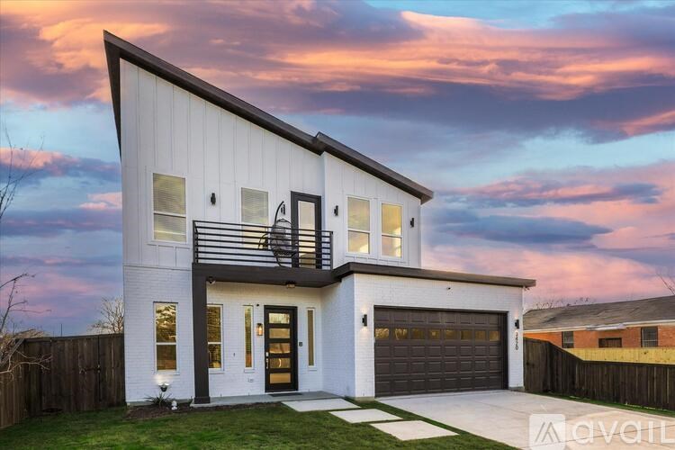 A modern two-story house with a balcony on the upper floor.