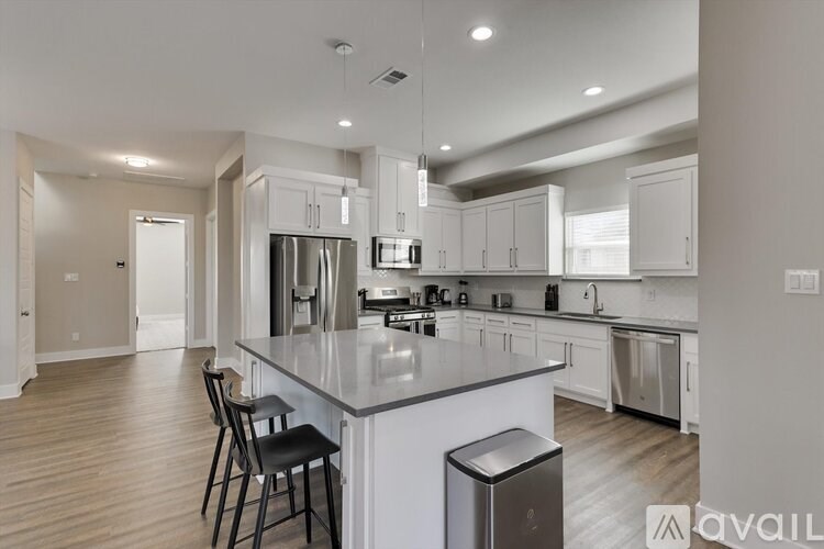 A modern kitchen with a large island and stainless steel appliances.