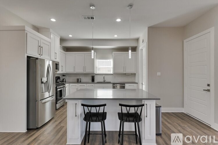 A modern kitchen with a center island and two chairs.