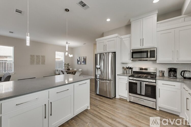 A kitchen with white cabinets and stainless steel appliances.