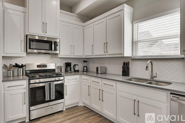 A kitchen with white cabinets and a stainless steel oven.