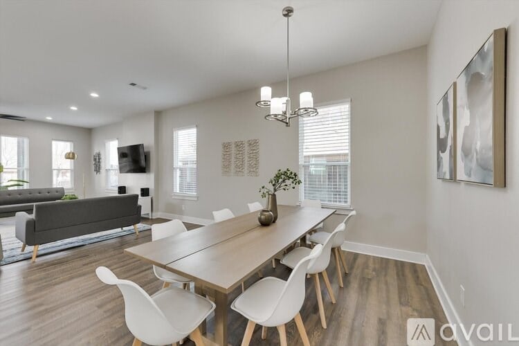 A modern dining room with a long table and chairs.