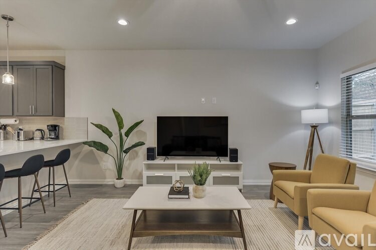A living room with a fireplace, chairs, and a coffee table.