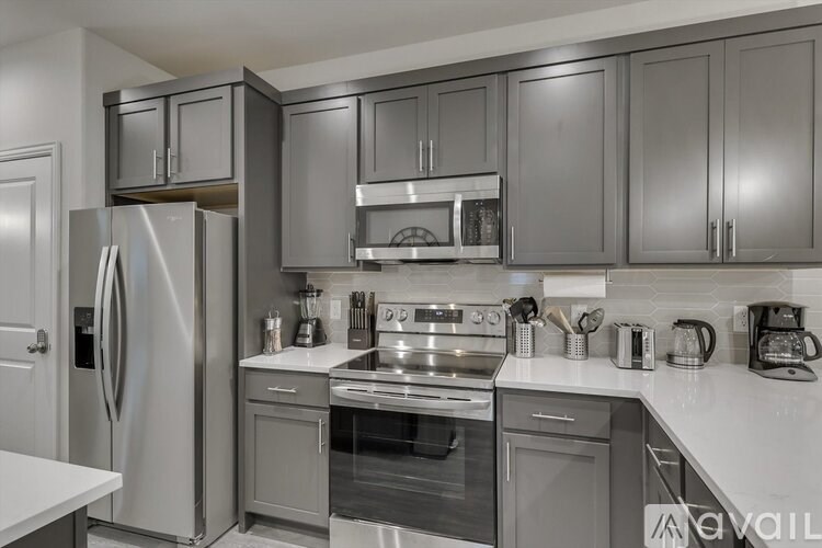 A modern kitchen with stainless steel appliances and dark wood cabinets.