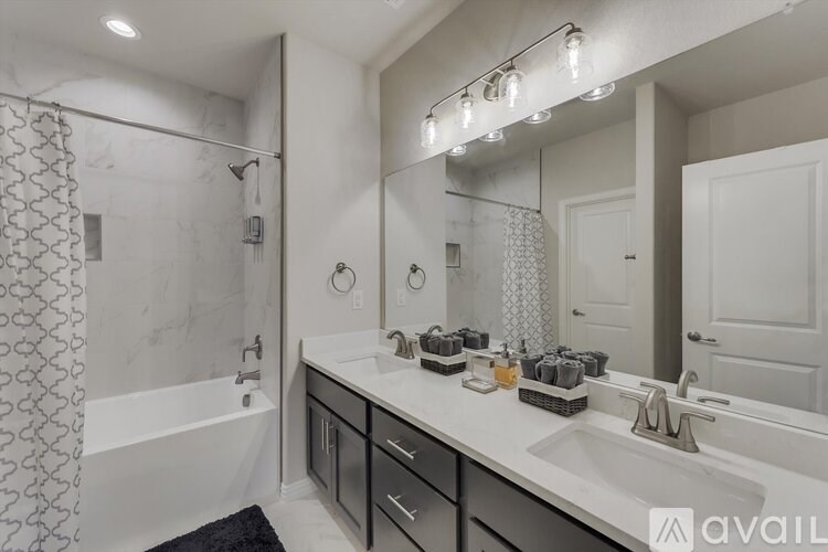 A bathroom with a white tub, sink, and shower.
