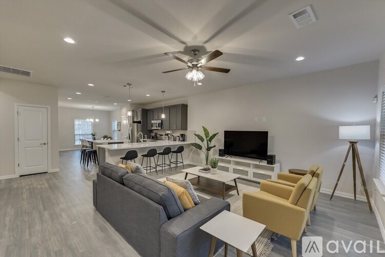A living room with a grey couch, a white table, and a television.
