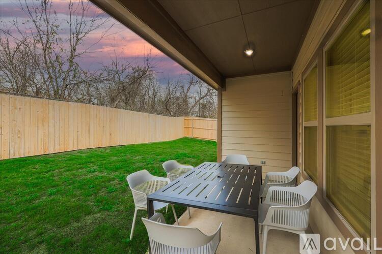 A patio with a table and chairs is set up on a lawn.