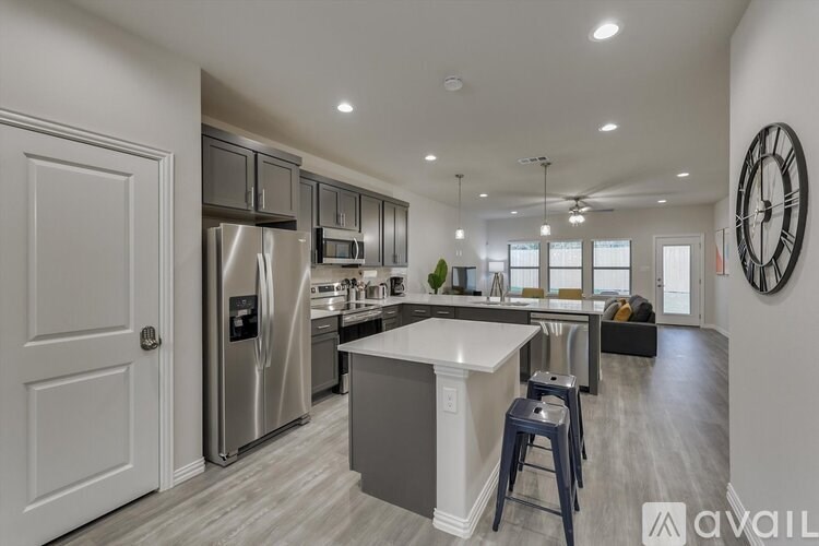 A modern kitchen with a large island and stainless steel appliances.