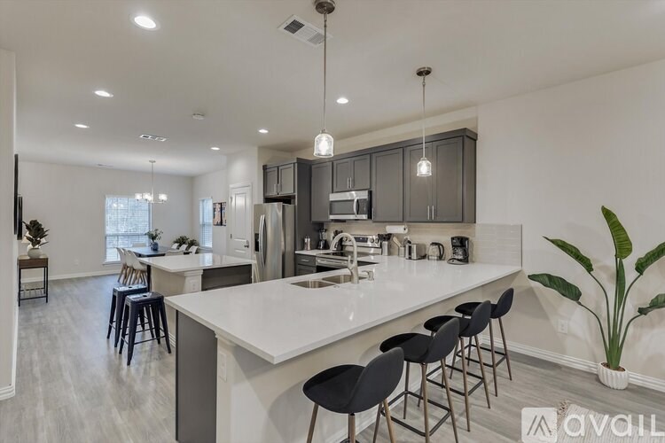 A modern kitchen with a large island and bar stools.