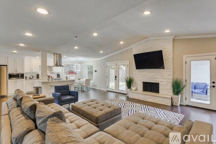 A modern living room with a fireplace and a television mounted on the wall.