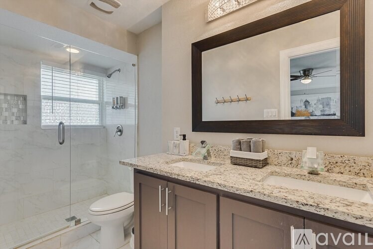 A bathroom with a toilet, sink, and mirror.