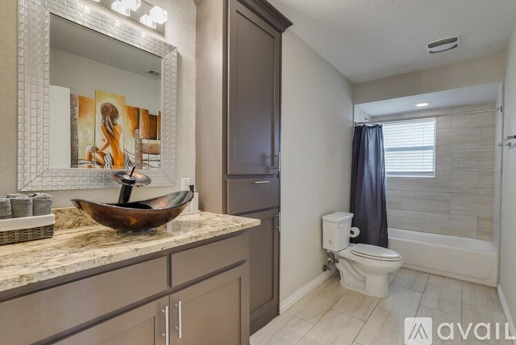 A bathroom with a marble countertop and a wooden bowl on it.