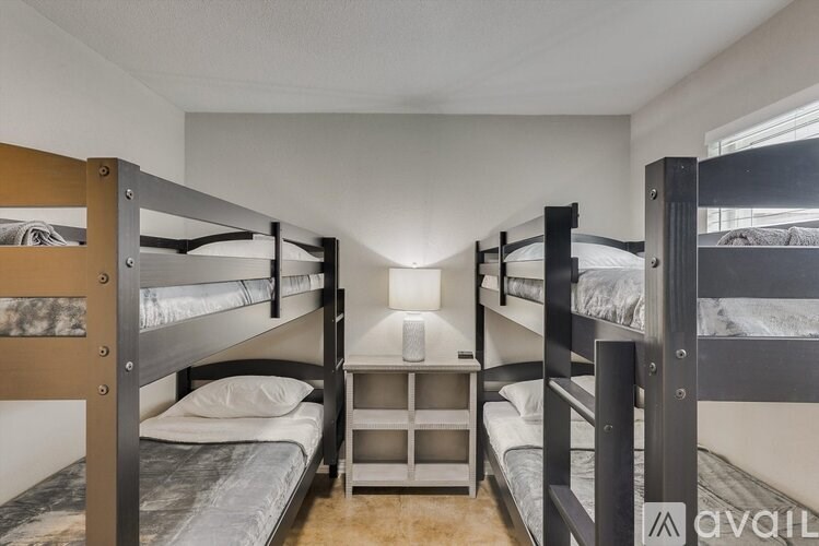 A room with bunk beds and a small table in the middle.