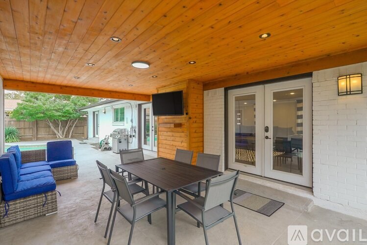 A wooden table with chairs is set up on a patio.