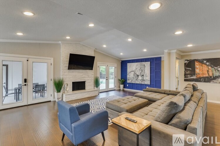 A living room with a grey couch, a blue armchair, and a fireplace.