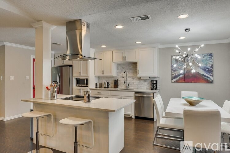 A modern kitchen with white cabinets and a large island.