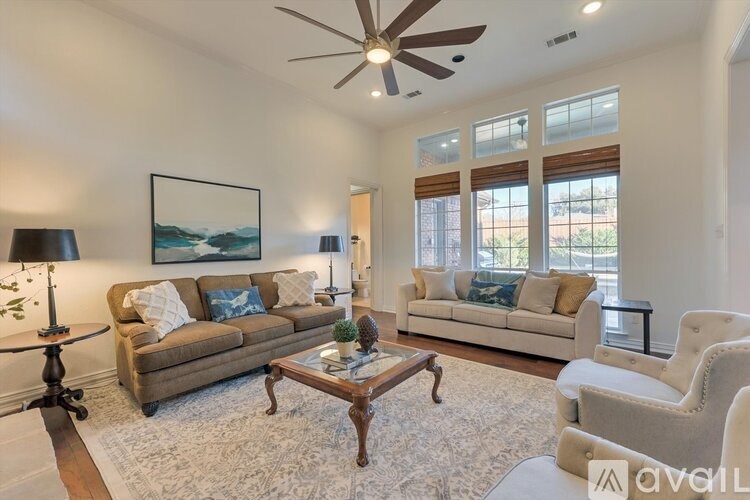 A living room with a ceiling fan, two couches, and a coffee table.