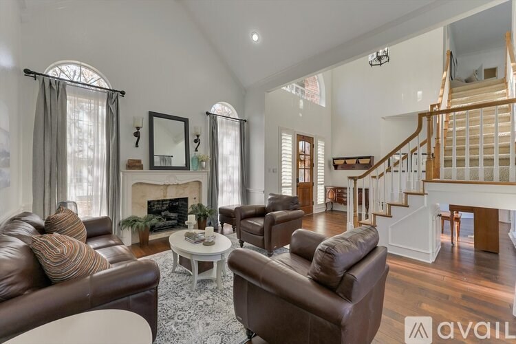 A living room with brown leather couches and a white fireplace.
