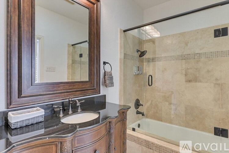 A bathroom with a marble countertop and a wooden vanity.