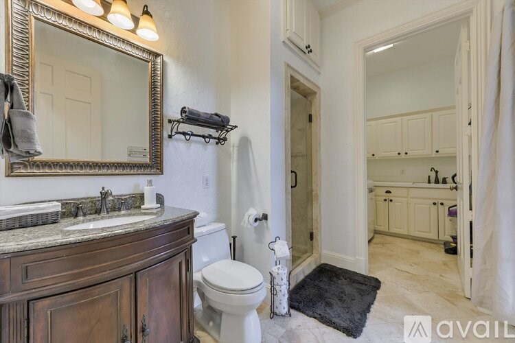 A bathroom with a toilet, sink, and mirror.