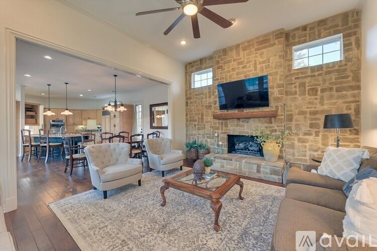 A living room with a stone wall and a fireplace.
