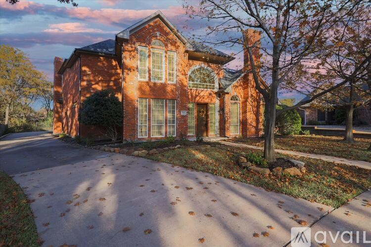 A large brick house with a driveway in front.