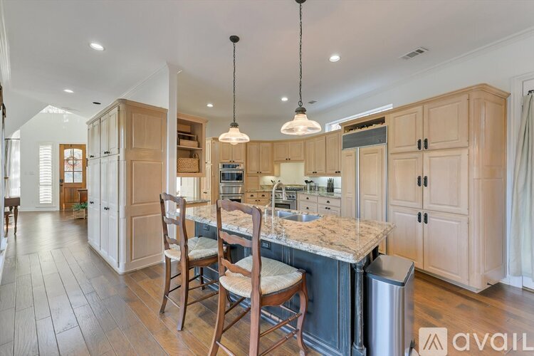 A kitchen with wooden cabinets and a marble countertop.