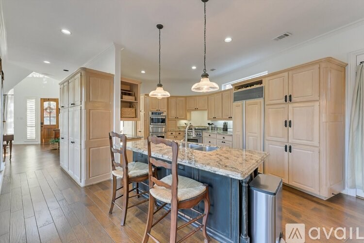 A kitchen with wooden cabinets and a marble countertop.