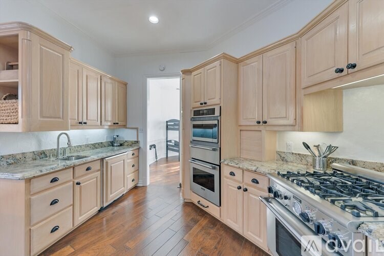 A kitchen with wooden cabinets and a marble countertop.