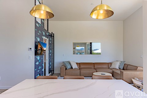 A living room with a couch, chairs, and a painting on the wall.
