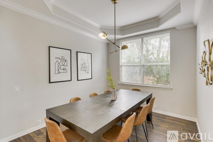 A dining room with a table and chairs.