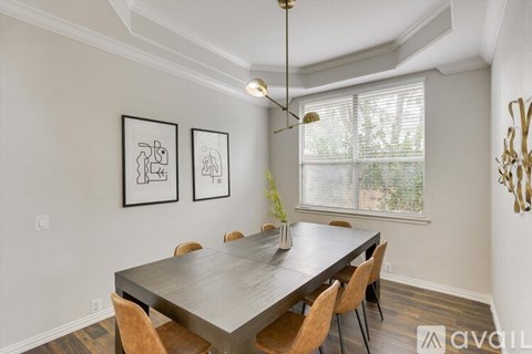 A dining room with a table and chairs.