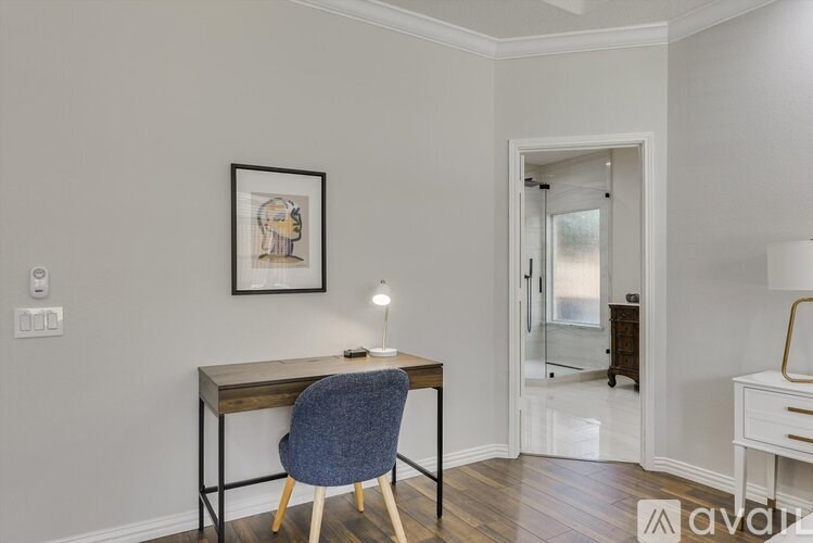 A room with a desk and chair in it.