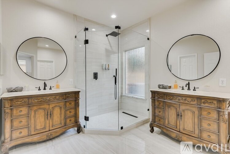 A bathroom with a wooden vanity and two round mirrors.