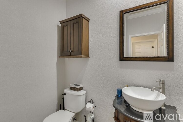 A bathroom with a toilet, sink, and medicine cabinet.