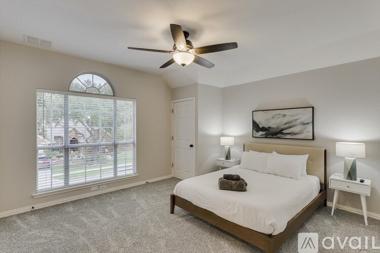 A bedroom with a bed, nightstand, and window.