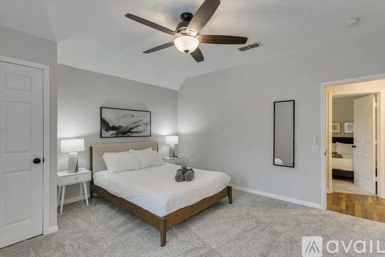 A bedroom with a bed, nightstands, and a ceiling fan.