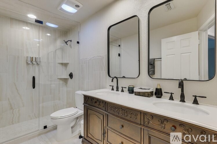 A bathroom with a toilet, sink, and mirror.