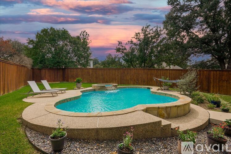 A backyard with a pool and a wooden fence.
