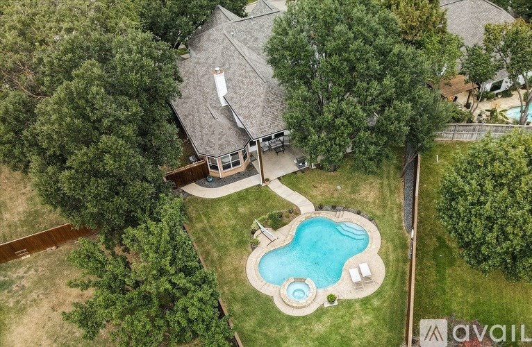 A house with a pool surrounded by trees.
