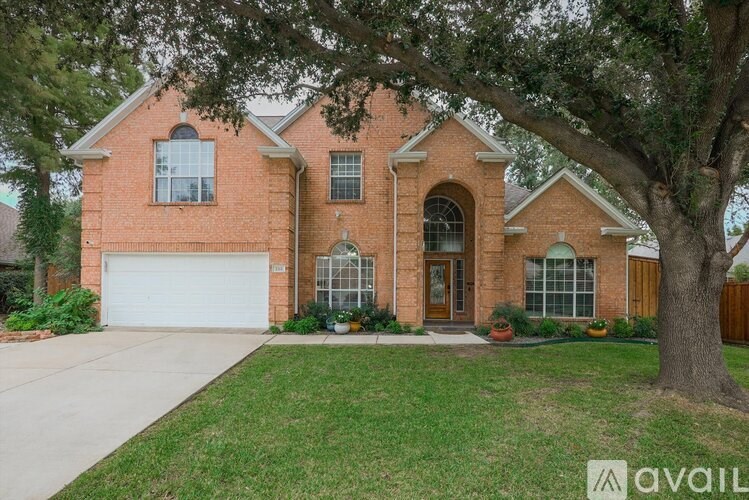 A large house with a tree in front.