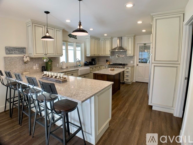 A kitchen with white cabinets and a granite countertop.